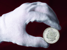 Coins should be held by their edges between thumb and forefinger.